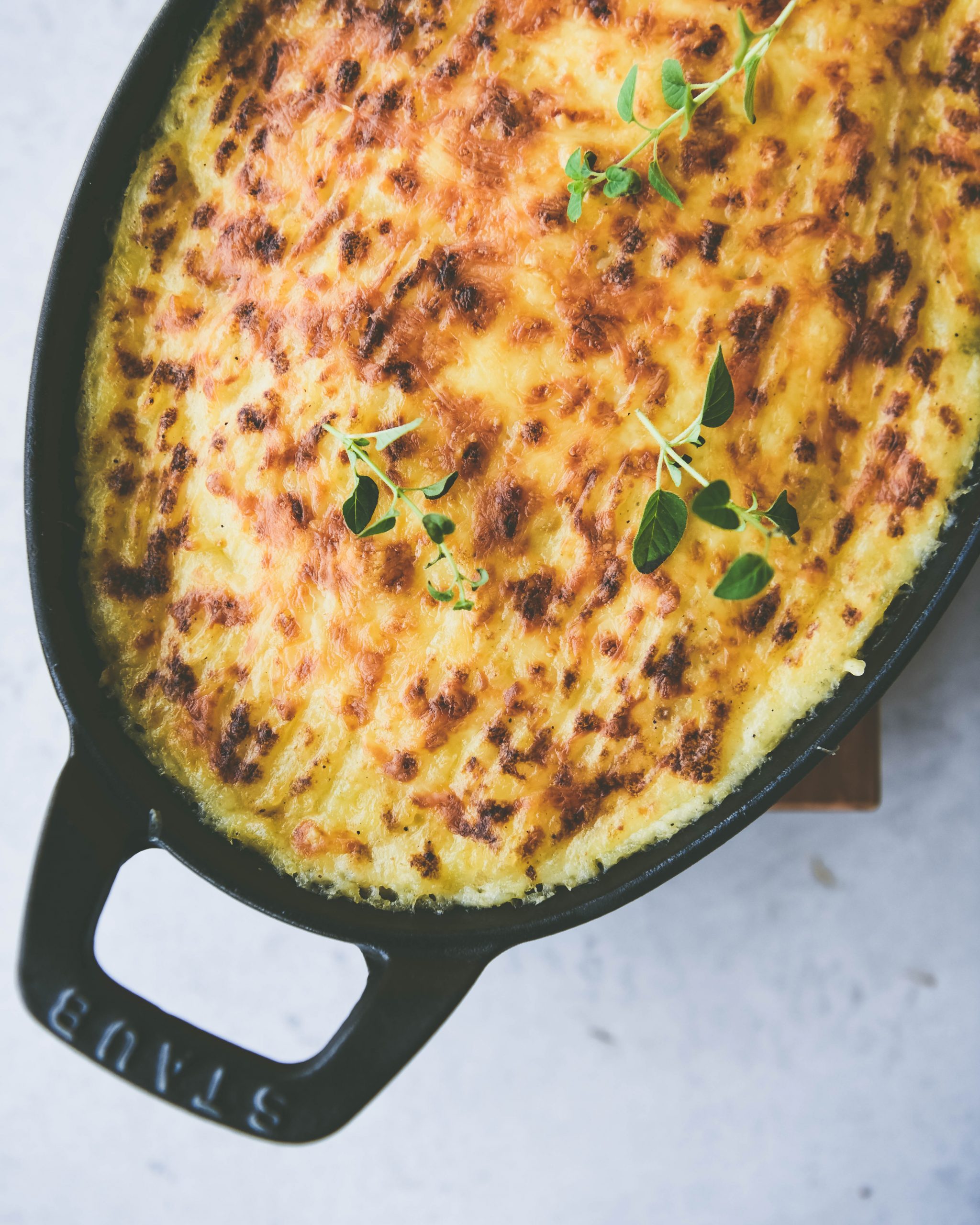 White background, black cast iron pan, top view of Spiced Shepherd's Pie